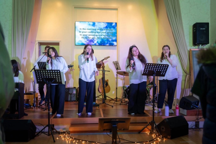 Singers on a low stage at a Sunday gathering